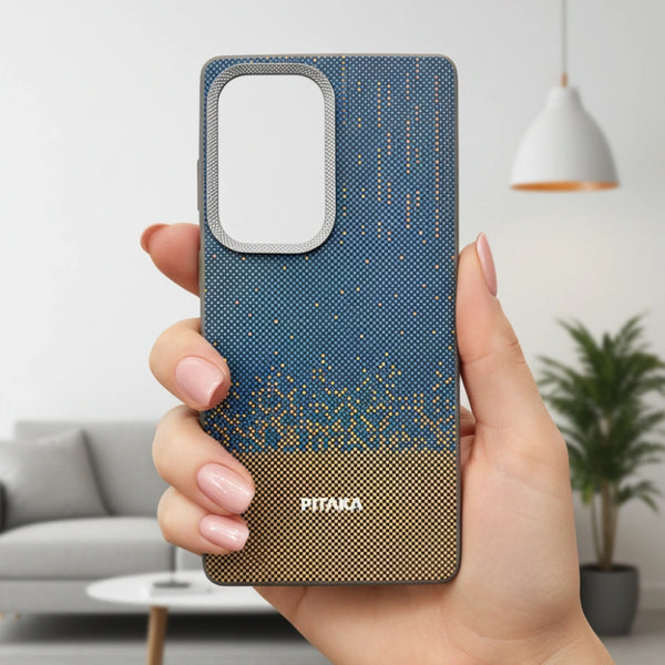 Hand holding a PITAKA Casetify Samsung blue and brown patterned phone case in a living room setting
